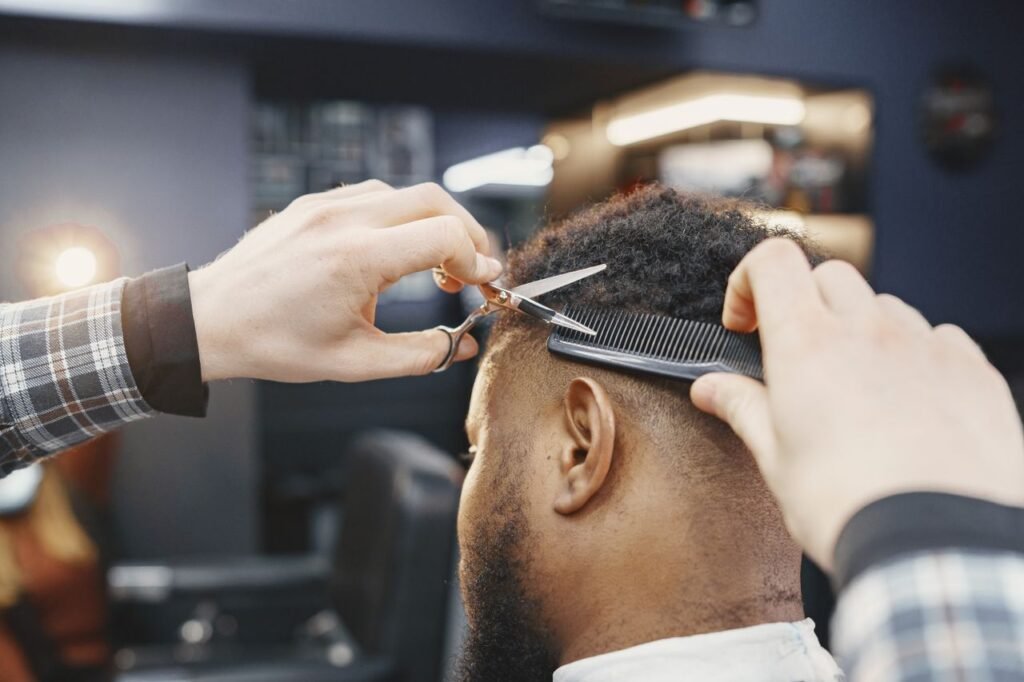 Close-up of a barber giving a haircut with scissors and comb in a modern salon.